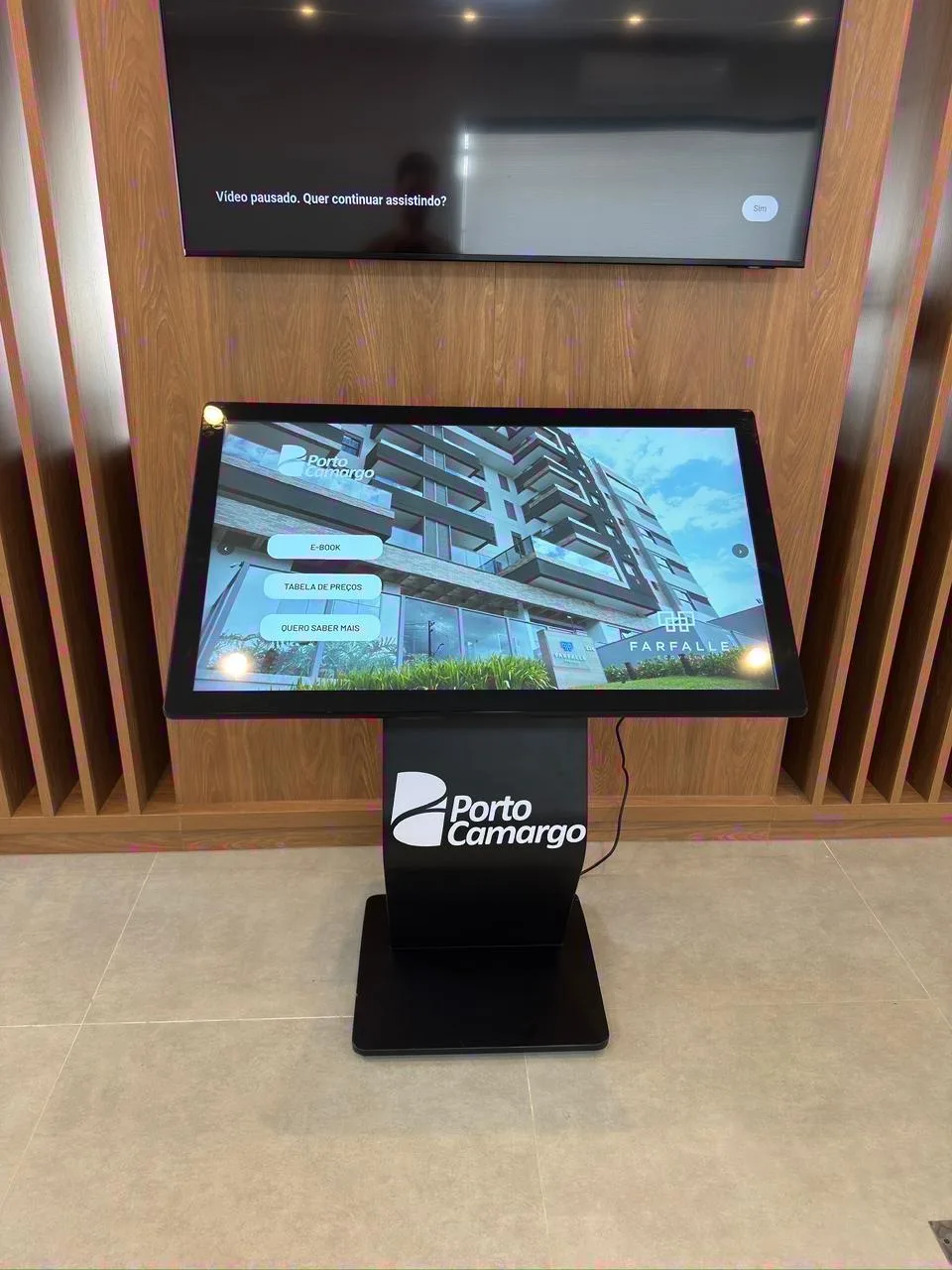 Totem horizontal com marca aplicada ao pedestal e plantas de empreendimento na tela