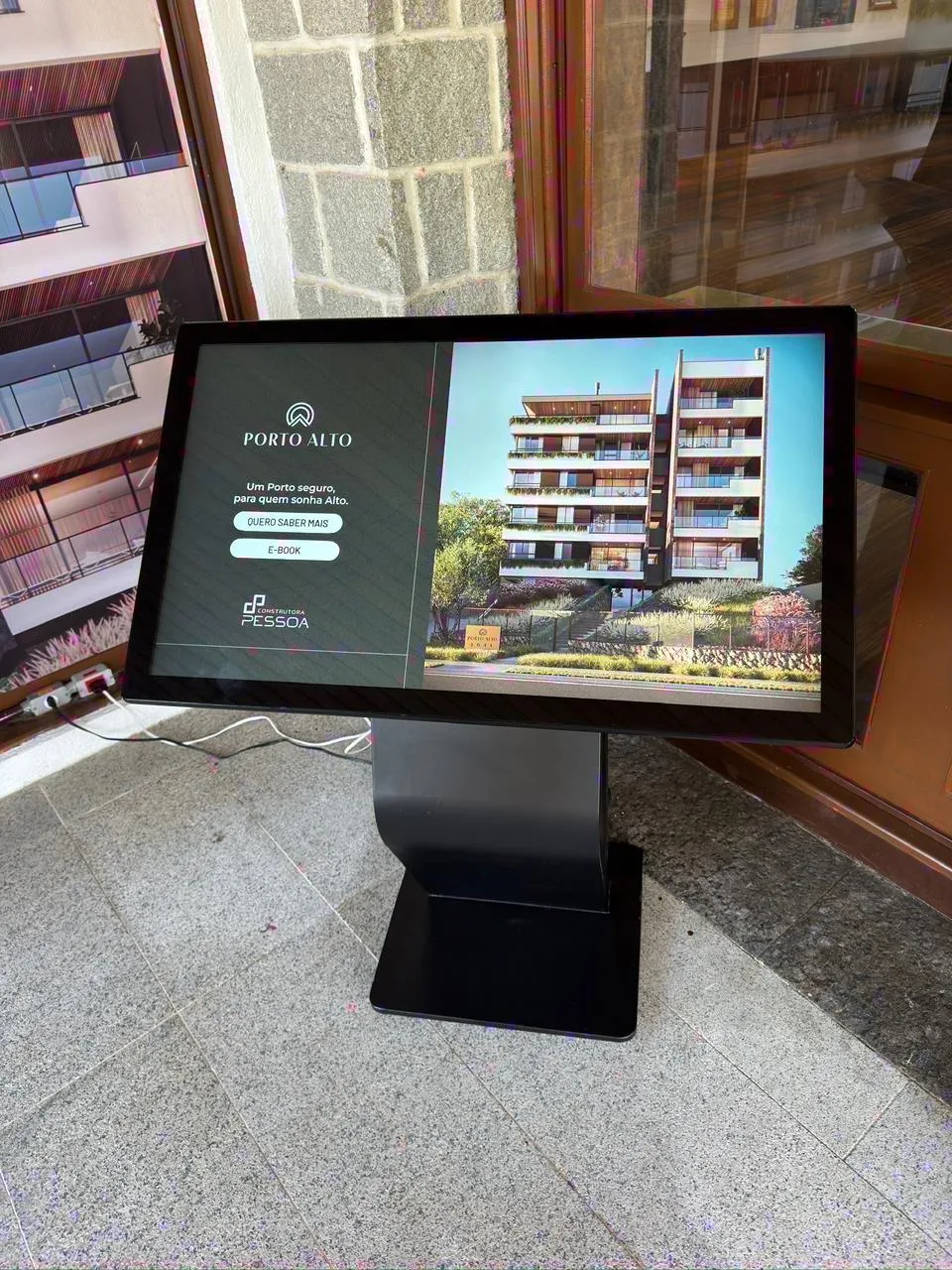 Totem horizontal de 43 polegadas em showroom, com apresentação de empreendimento
