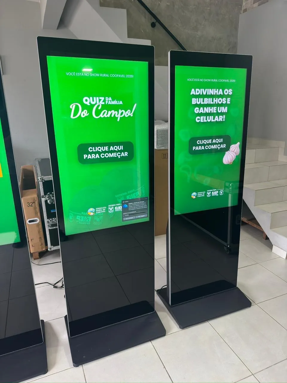 Dois totens verticais com identidade visual verde aplicada